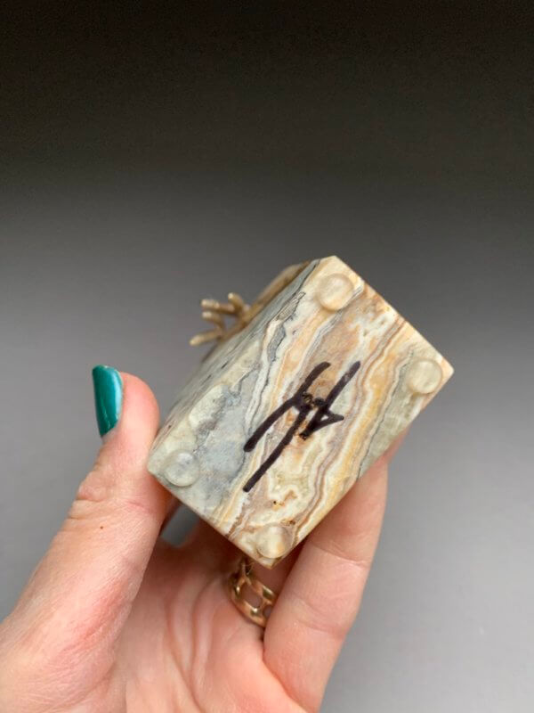 Yenny Cocq signature on natural stone base