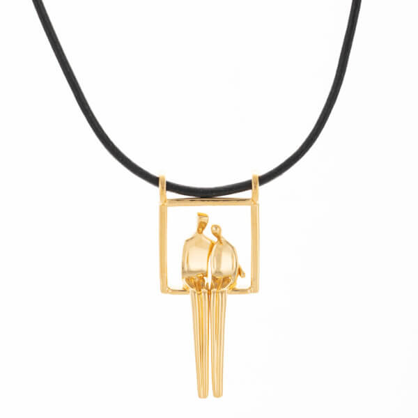 Gold pendant of embracing couple by Yenny Cocq