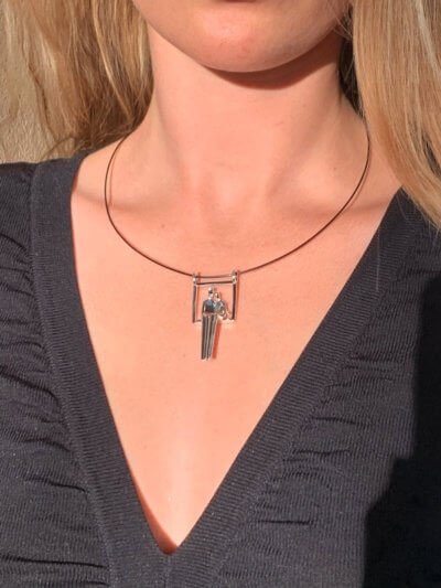 Woman's neck showing pendant of couple seated in embrace