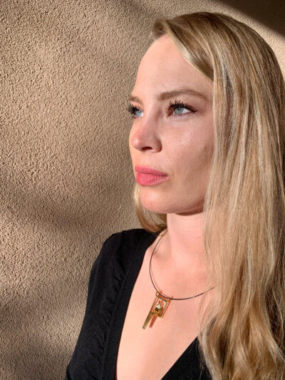 Woman wears gold pendant of couple sitting next to each other