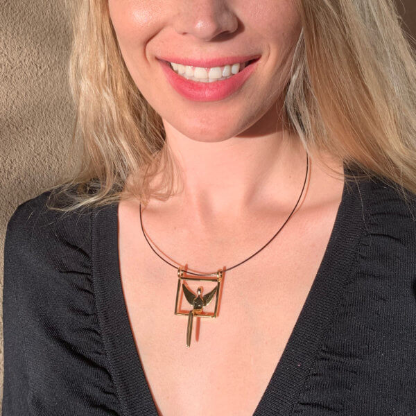 Smiling woman wearing gold angel pendant