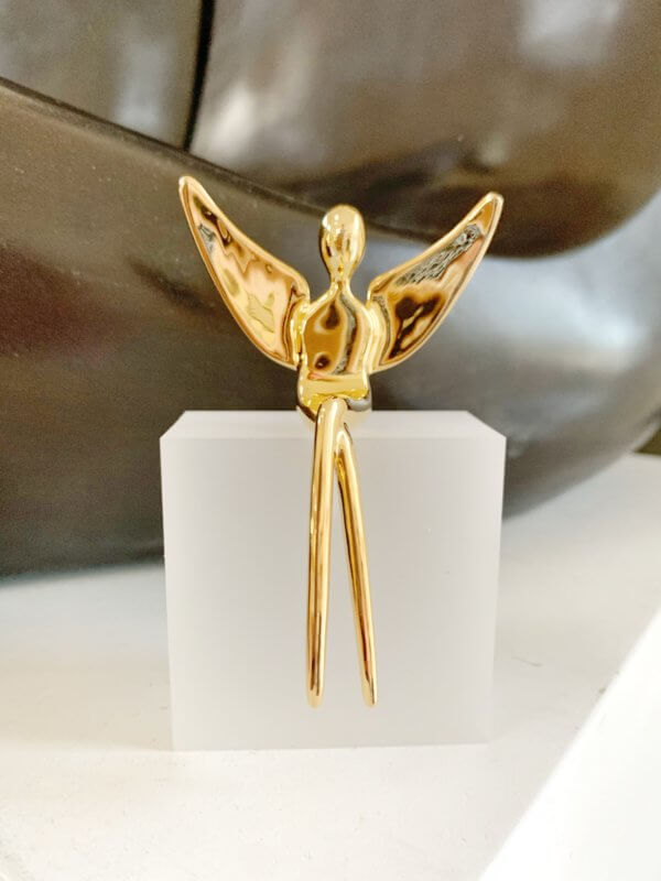 Gold angel sculpture on an acrylic base.