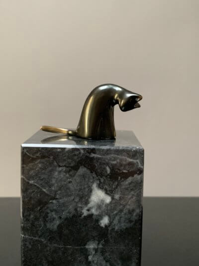 Grooming cat statue on base