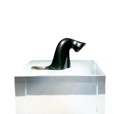 Bronze cat sculpture of a grooming cat.