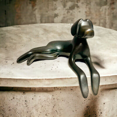 lying down dog sculpture in bronze