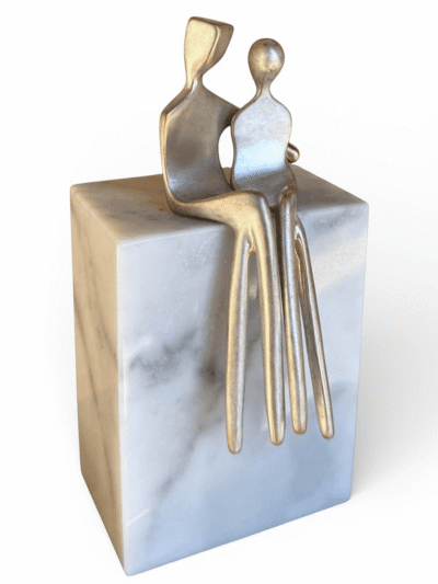 Abstract brushed silver sculpture on white Carrera marble base for modern home decor.
